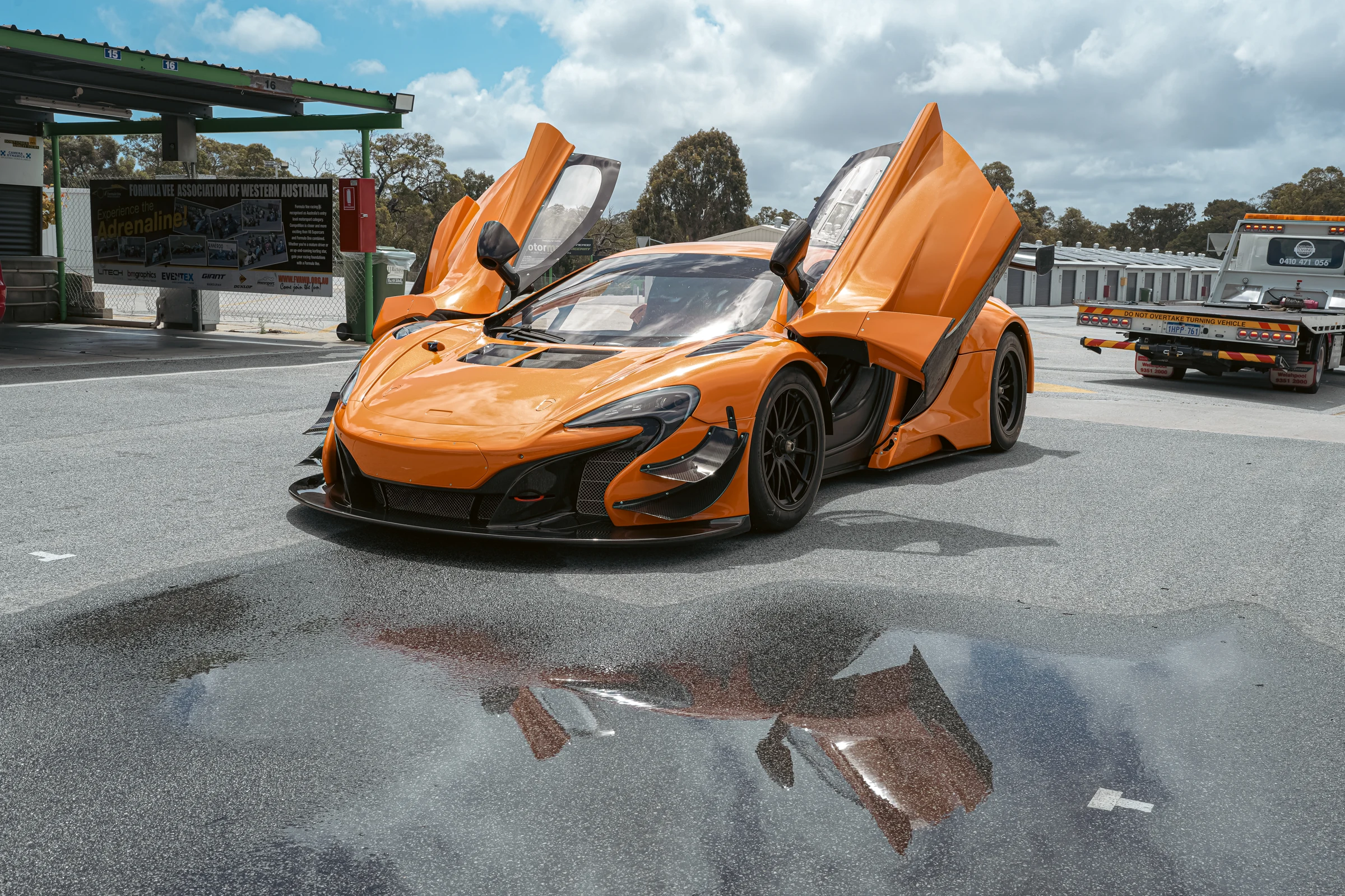 The actual orange RLRC McLaren 650S GT3, doors open in the paddock