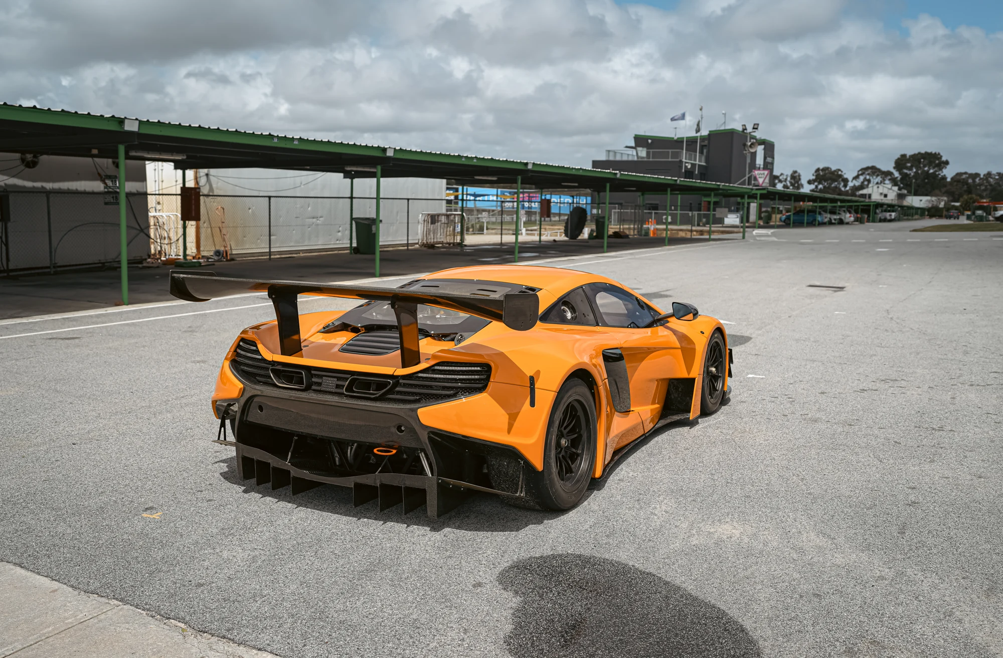 Rear three-quarter photograph showing the McLaren's racing wing and diffuser